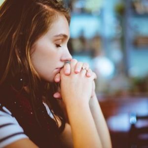 Jovem rezando dentro da igreja