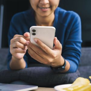 Mulher mexendo no telefone celular e divulgando sua vaquinha online