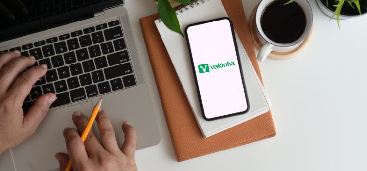 Pessoa fazendo login no site do vakinha no computador e telefone