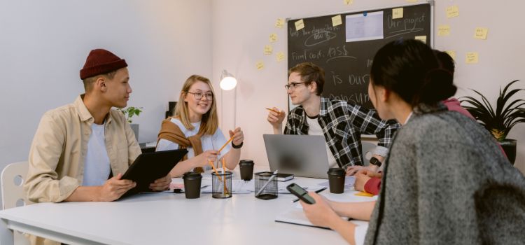 Pessoas reunidas em sala de reunião falando sobre crowdfunding