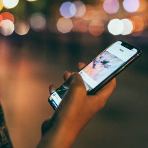 Pessoa com telefone na mão usando o Instagram