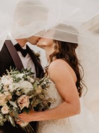 Noivos se beijando em casamento ao ar livre