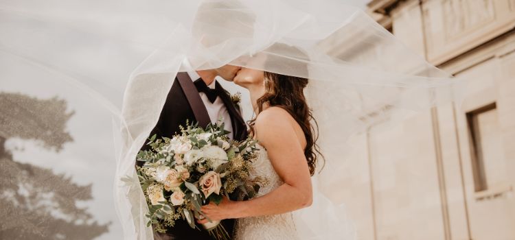 Noivos se beijando em casamento ao ar livre