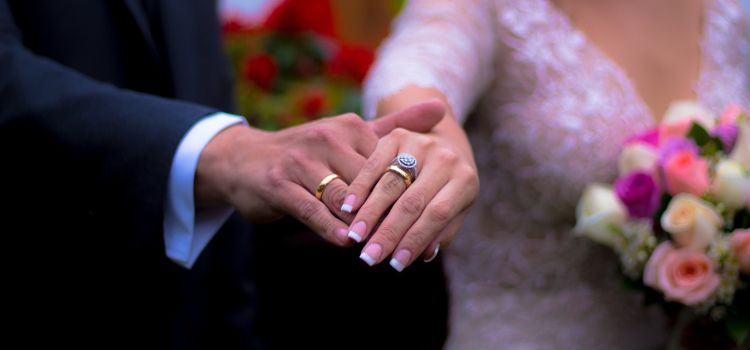 Noivos se casamento e mostrando a aliança para foto