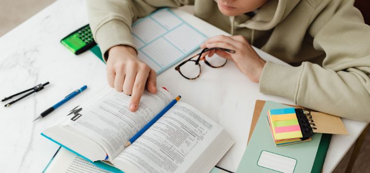 Estudante com livro na mesa estudando