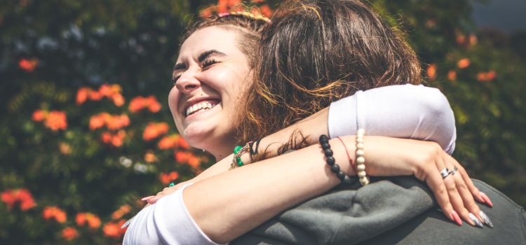 Pessoas se abraçando e sorrindo