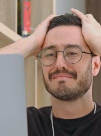 Homem com a mão na cabeça triste em frente ao computador