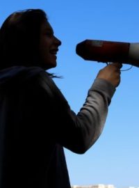 Pessoa com megafone na mão divulgando vaquinha online na rua