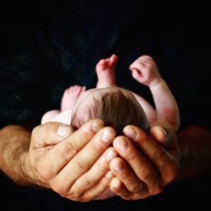 Pai segurando bebê com as mãos