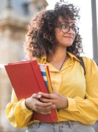 Estudante com livros na mão na rua