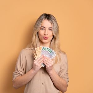 Mulher com notas de dinheiro na mão após empréstimo