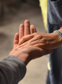 Pessoa ajudando outra pessoa e pegando na mão