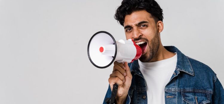 Homem com megafone na mão gritando