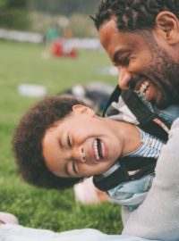 Pai e filho abraçados na grama